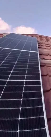 Close-up of monocrystalline solar panels mounted on a tile roof